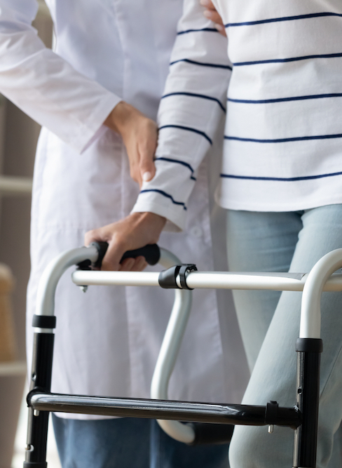 Cropped,Image,Caregiver,Helping,To,Disabled,Patient,Walking,With,Rollator